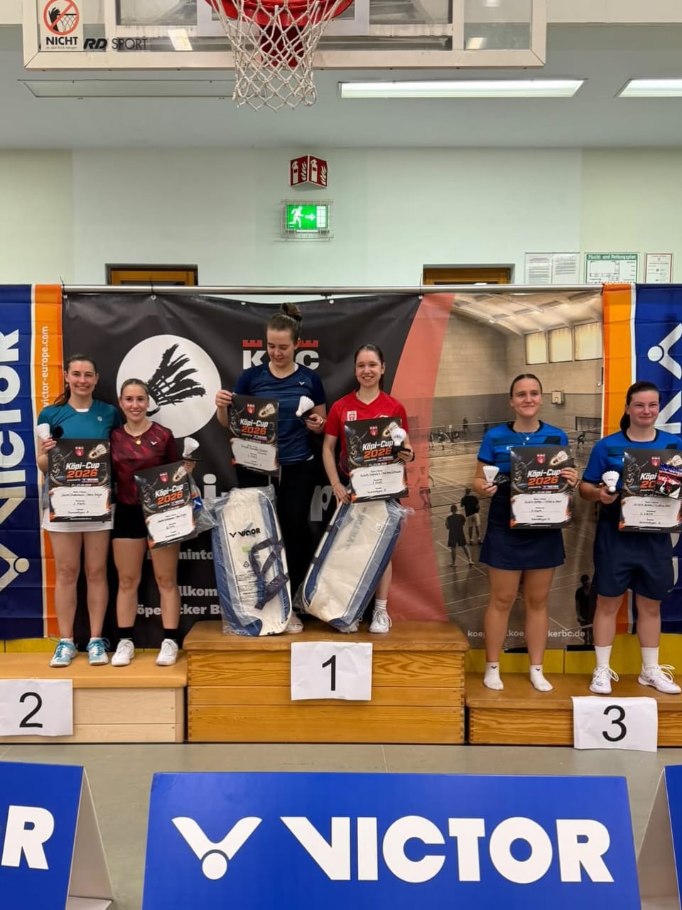 Sechs Spielerinnen mit Urkunden des Köpi-Cup 2026 auf dem Siegertreppchen mit den Plätzen 1, 2 und 3 in einer Sporthalle.
